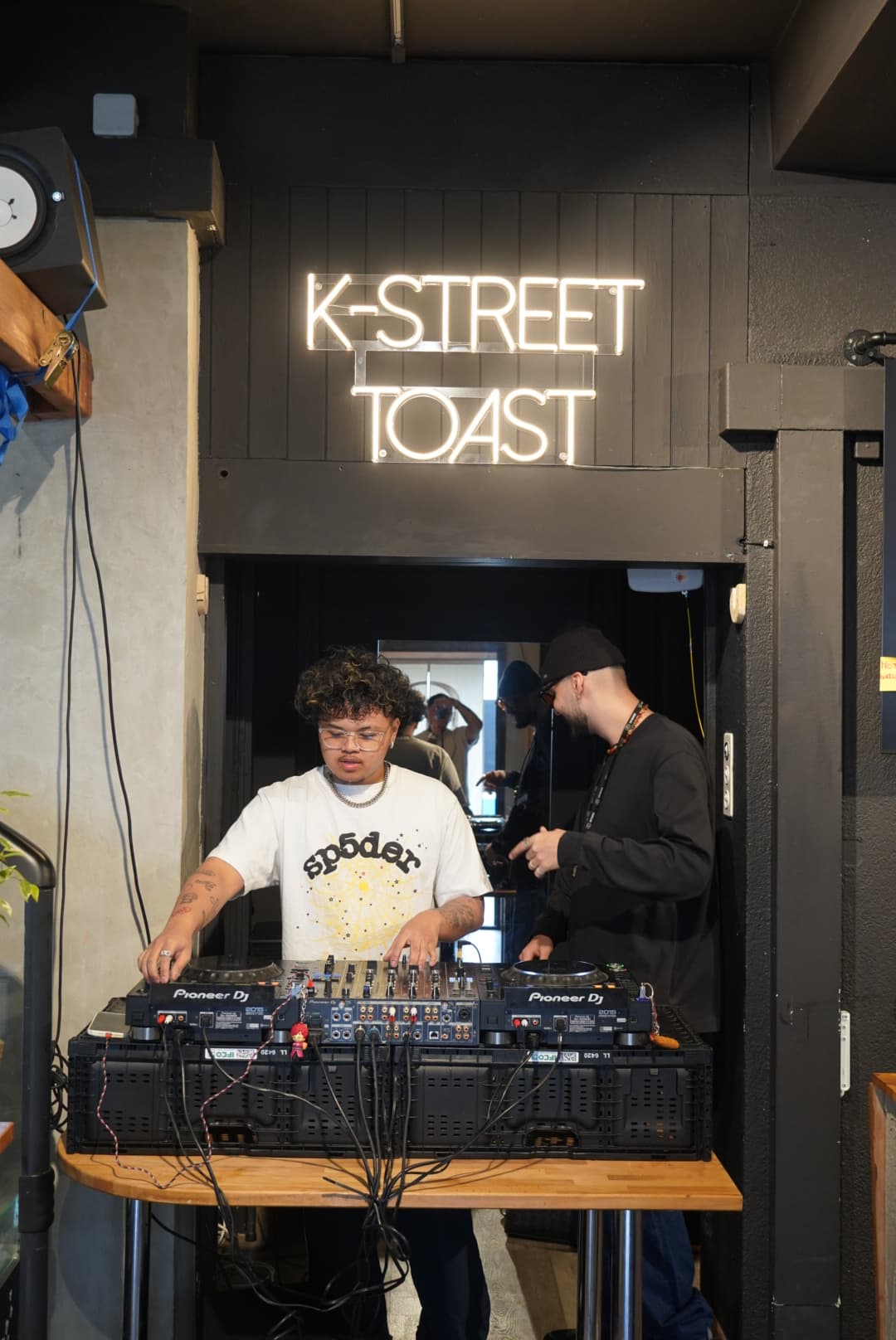 DJ set under the K-STREET TOAST neon sign