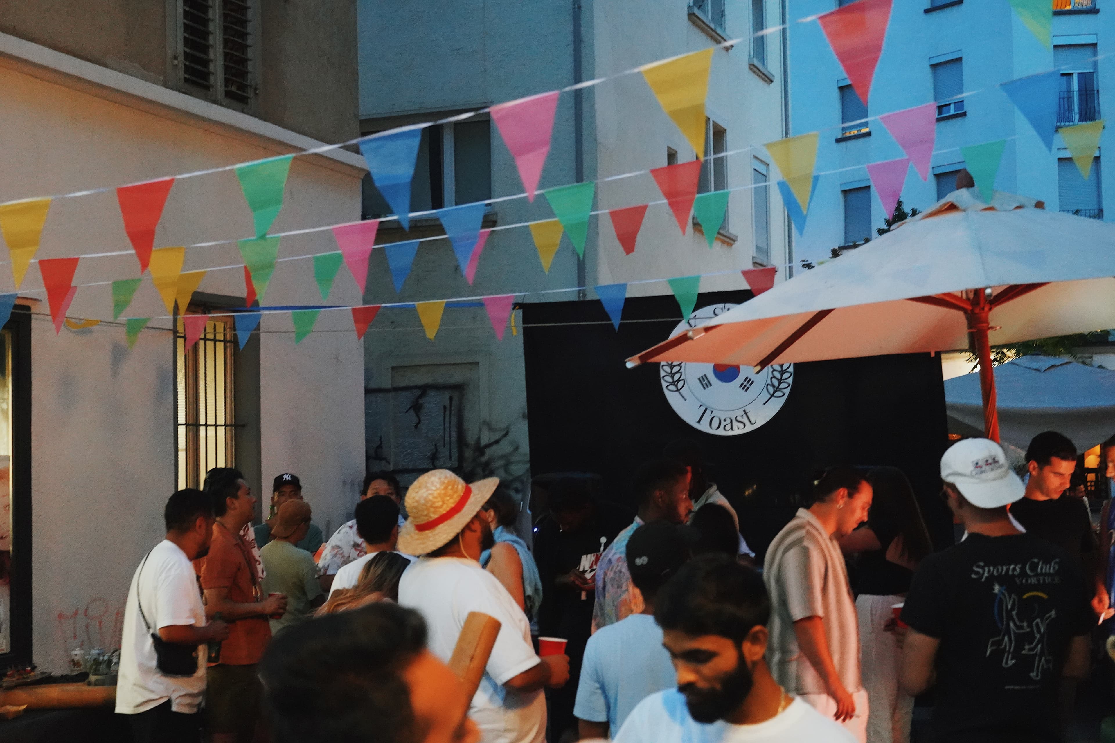 Crowd under colourful bunting at a K-STREET street party