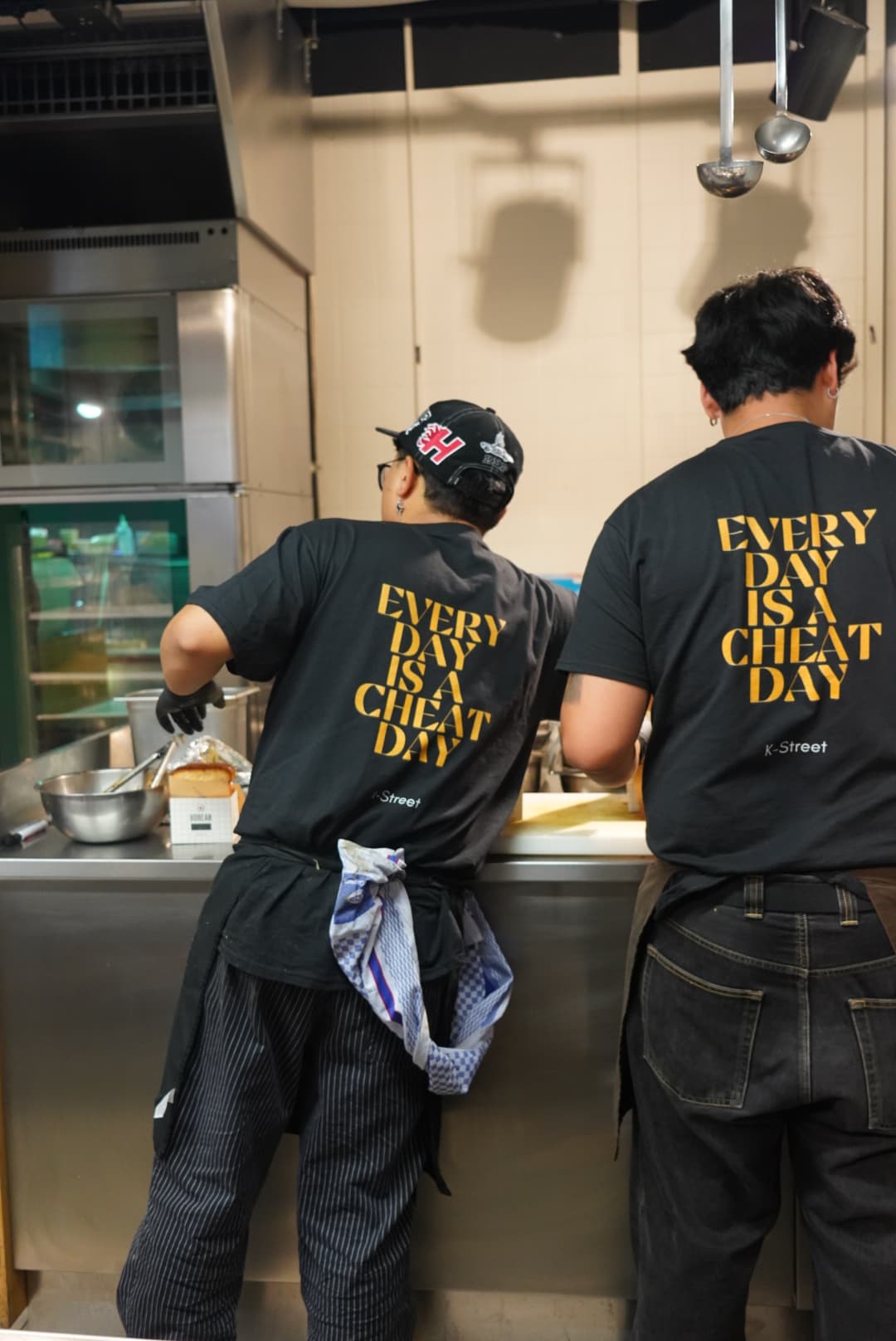 Two of the K-STREET team at work in matching Every Day Is A Cheat Day shirts
